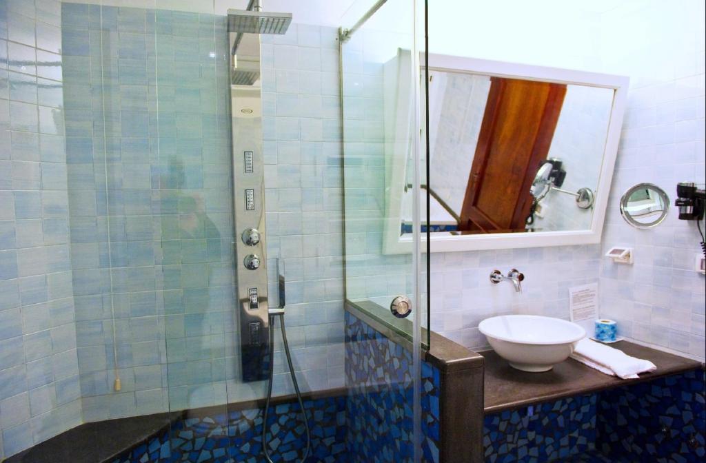 a bathroom with a sink and a glass shower at Hotel Palladio in Giardini Naxos