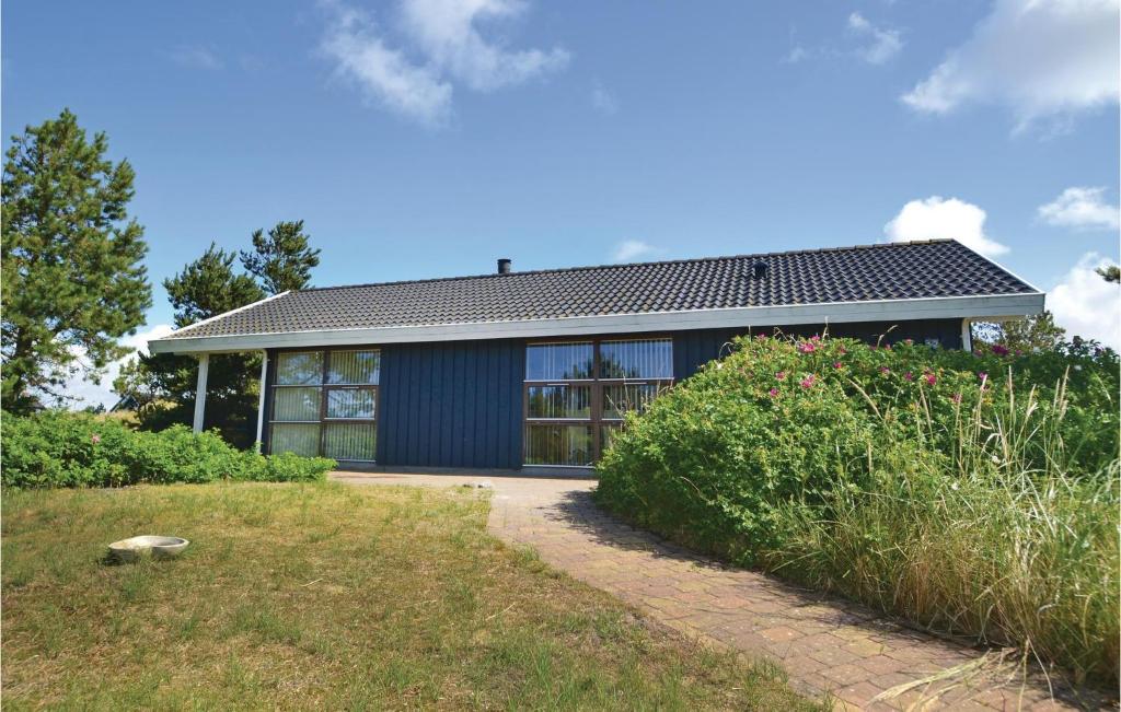 une maison avec une façade bleue et une cour dans l'établissement Amazing Home In Fan With Kitchen, à Fanø