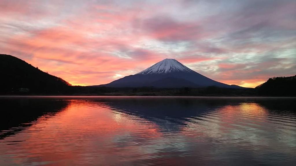 une montagne avec une réflexion dans l'eau au coucher du soleil dans l'établissement Shoji Mount Hotel, à Fujikawaguchiko