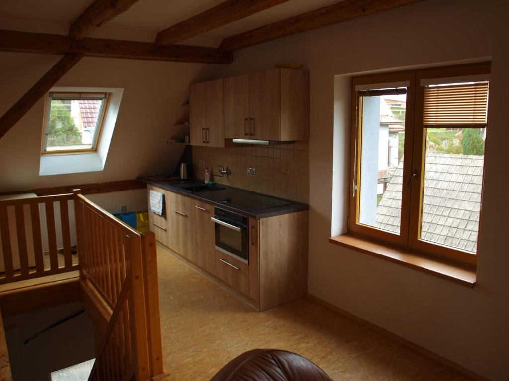 uma cozinha com armários de madeira e uma escada numa casa em apartman17 em Syřenov