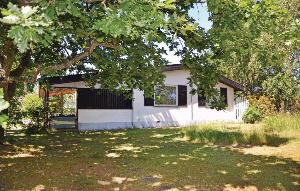 a white house with a tree in the yard at Nice Home In Solrd Strand With Kitchen in Karlstrup Strand