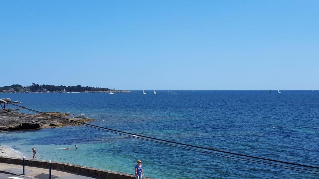 un grupo de personas en el agua en una playa en Studio face à la mer en Concarneau