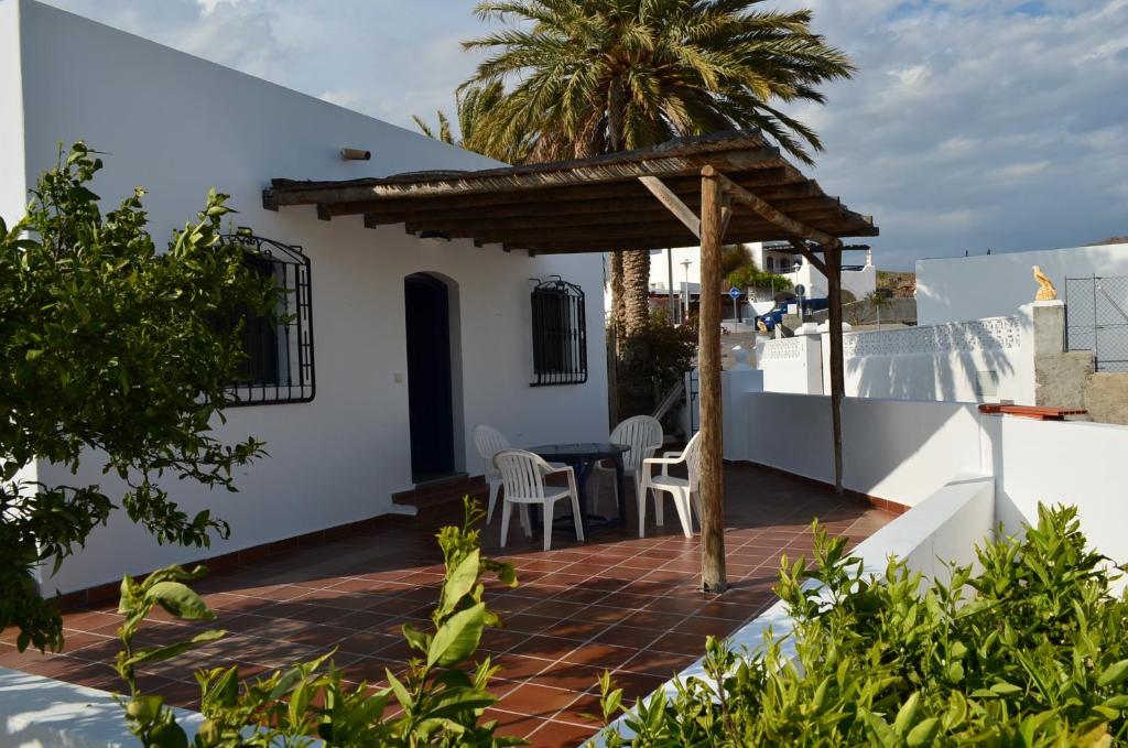 a patio with a table and a wooden pergola at Casas la Noria in Las Negras