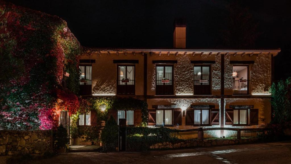 un edificio con luces de Navidad encendidas por la noche en Hospedería del Valle Boutique Apartments, en Gargantilla del Lozoya