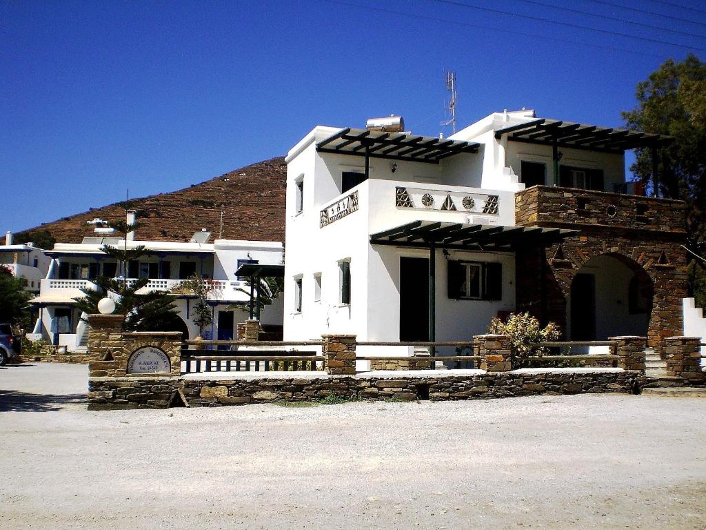 un bâtiment blanc avec une clôture devant lui dans l'établissement Porto Apergis, à Agios Ioannis