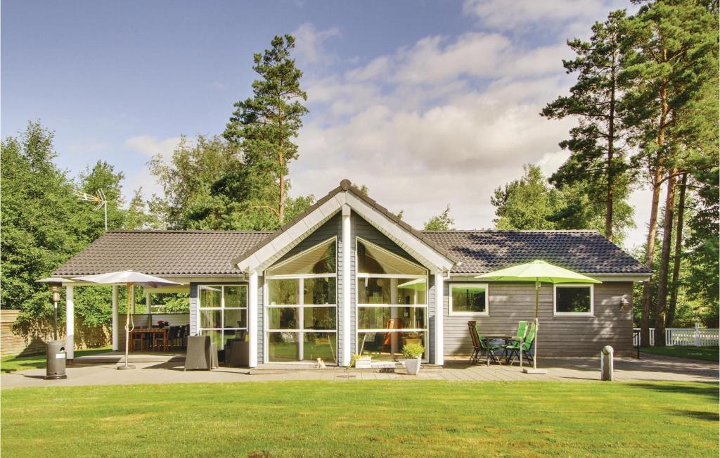 a house with a conservatory on a lawn at Beautiful Home In Ebeltoft With Kitchen in Ebeltoft