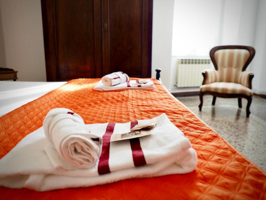 uma cama com duas toalhas e um roupão em DIMORA SARZANO ACQUARIO - GENOVABNB it em Gênova