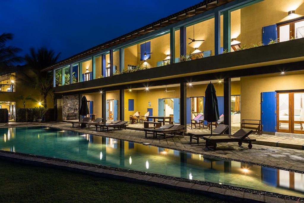 un hôtel avec une piscine en face d'un bâtiment dans l'établissement Villa Atulya at Ocean's edge, à Mirissa