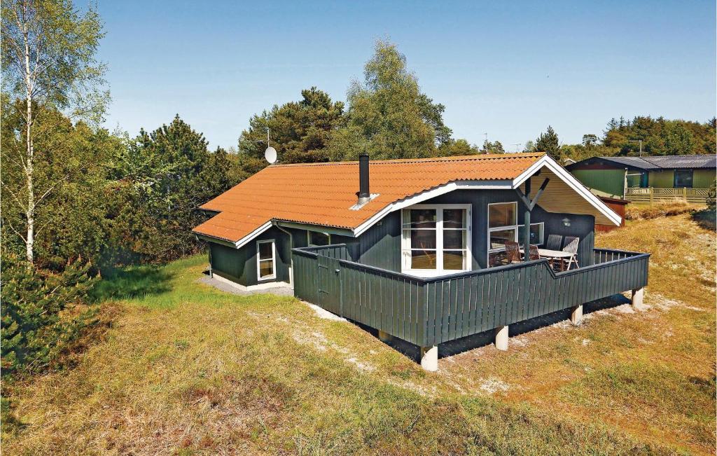 a small house with an orange roof on a field at Nice Home In Aakirkeby With House Sea View in Vester Sømarken