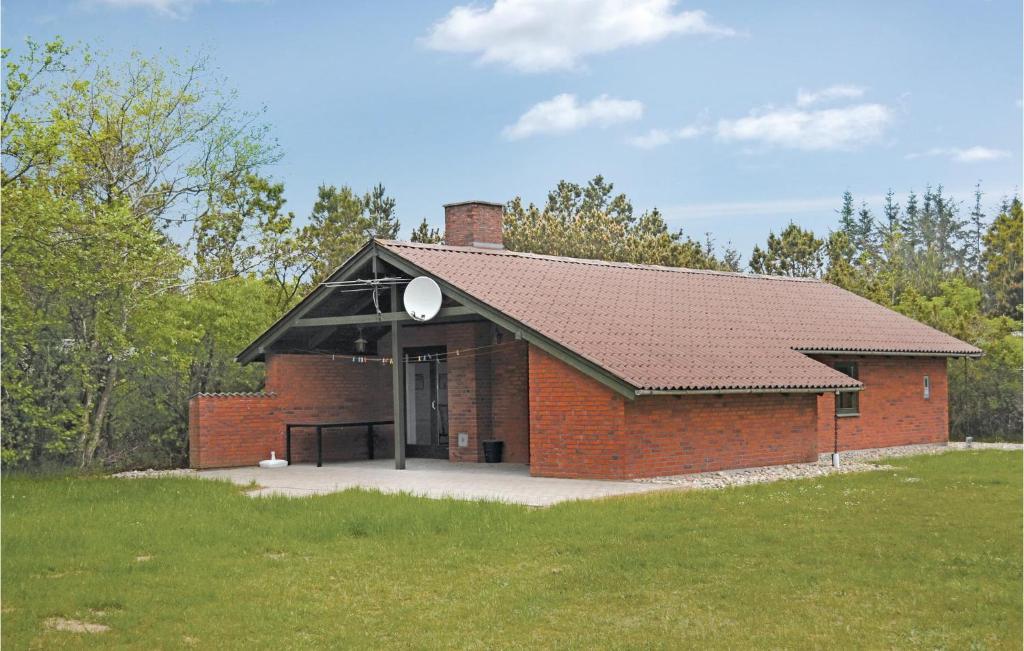 un bâtiment en briques rouges avec un toit noir dans l'établissement Holiday Home Fyrrekrogen Nørre Nebel Vi, à Lønne Hede