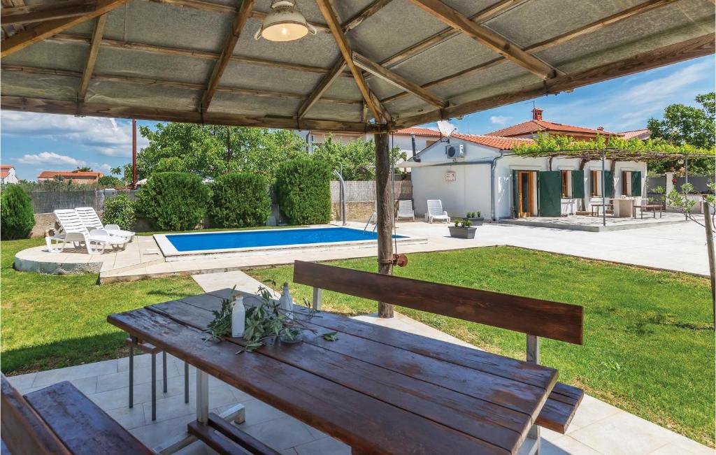 um quintal com uma mesa de madeira e uma piscina em Lovely Home In Pula With Kitchen em Pula