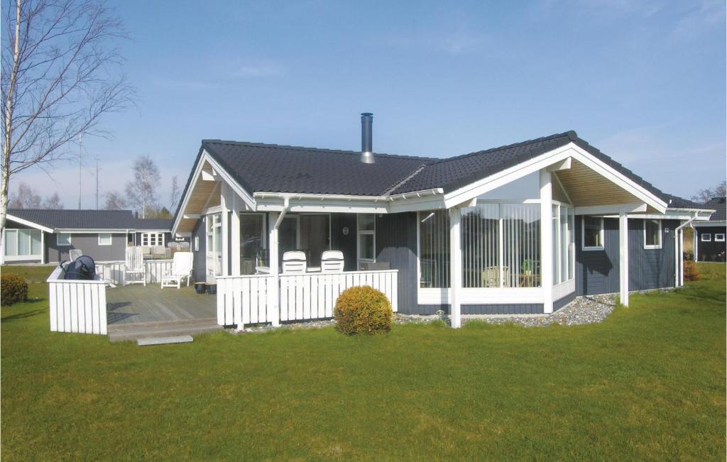 a house with a white fence in a yard at Gorgeous Home In Vggerlse With Wifi in Bøtø By