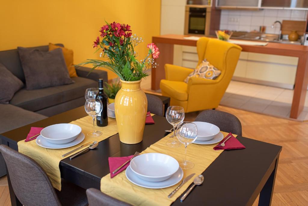 une salle à manger avec une table, des assiettes et des verres à vin dans l'établissement Patrik's Budapest Center Apartment, à Budapest