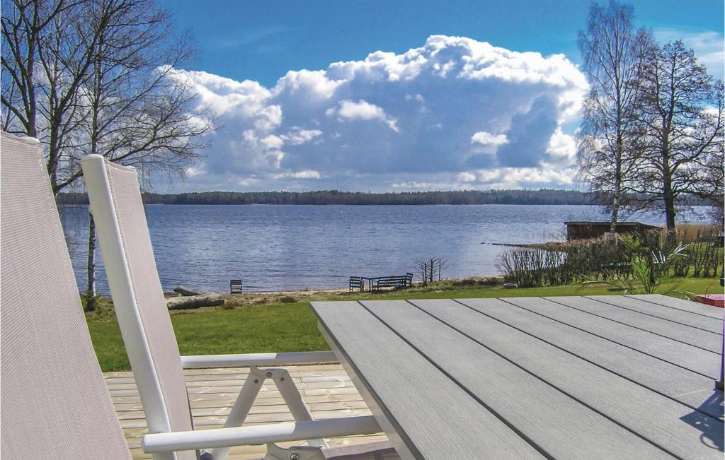 een witte stoel op een terras met uitzicht op een meer bij Beautiful home in Bolms with 3 Bedrooms and WiFi in Bolmsö