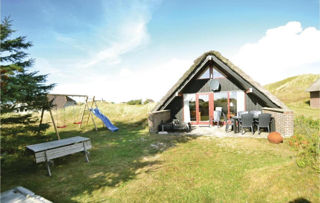 BjerregårdにあるGorgeous Home In Hvide Sande With Wifiの茅葺き屋根の家(ベンチ、遊び場付)