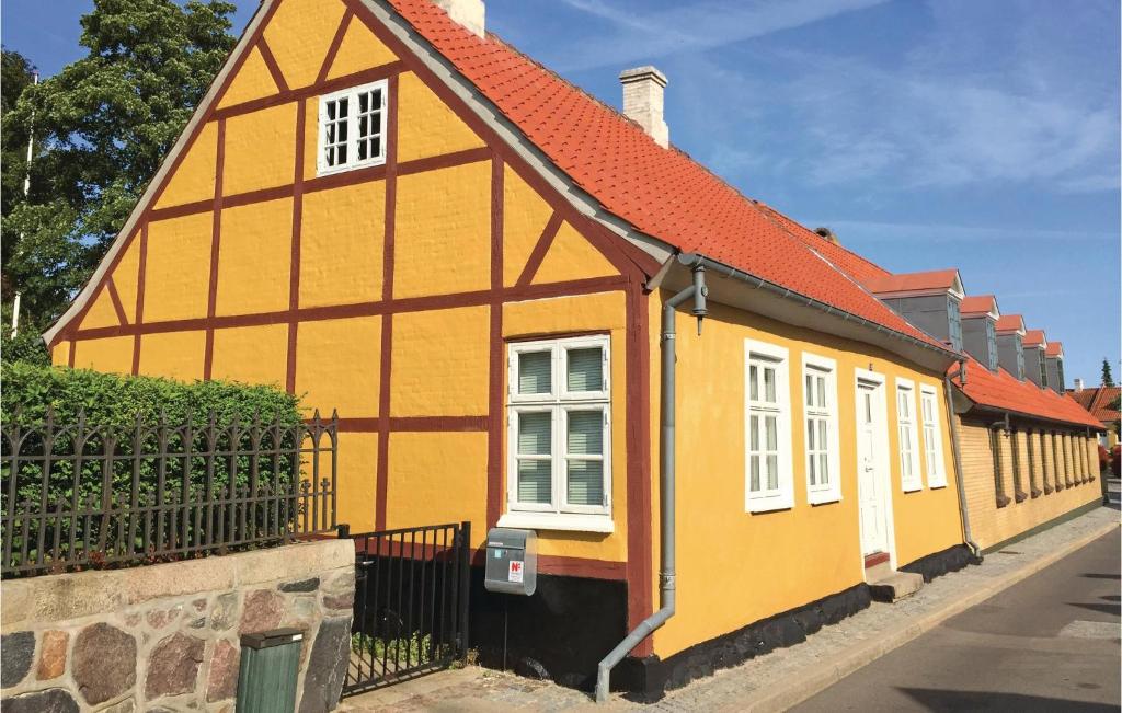 a yellow and orange house on a street at 2 Bedroom Gorgeous Home In Nysted in Nysted