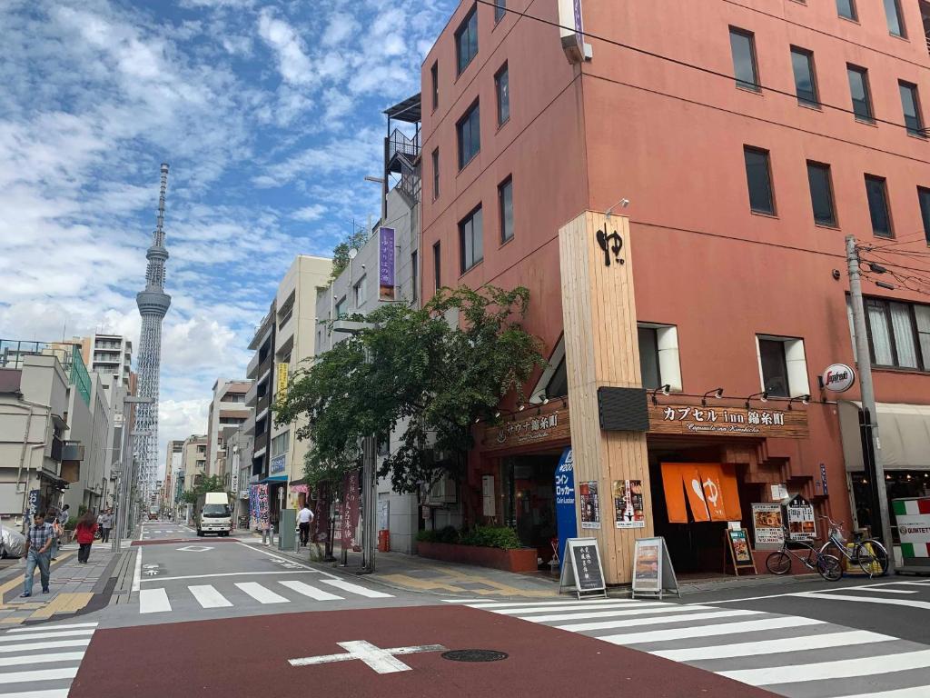 Une rue urbaine vide avec une tour de télévision en arrière-plan dans l'établissement Capsule Inn Kinshicho, à Tokyo