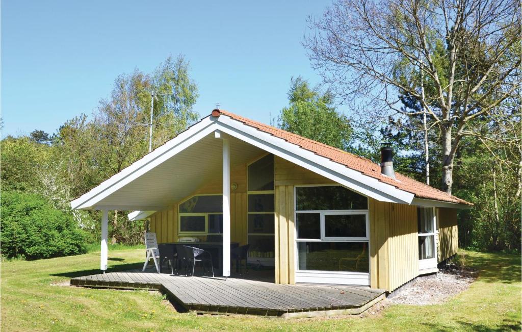 Ce petit cottage jaune dispose d'une terrasse dans la cour. dans l'établissement 2 Bedroom Pet Friendly Home In Vejby, à Vejby