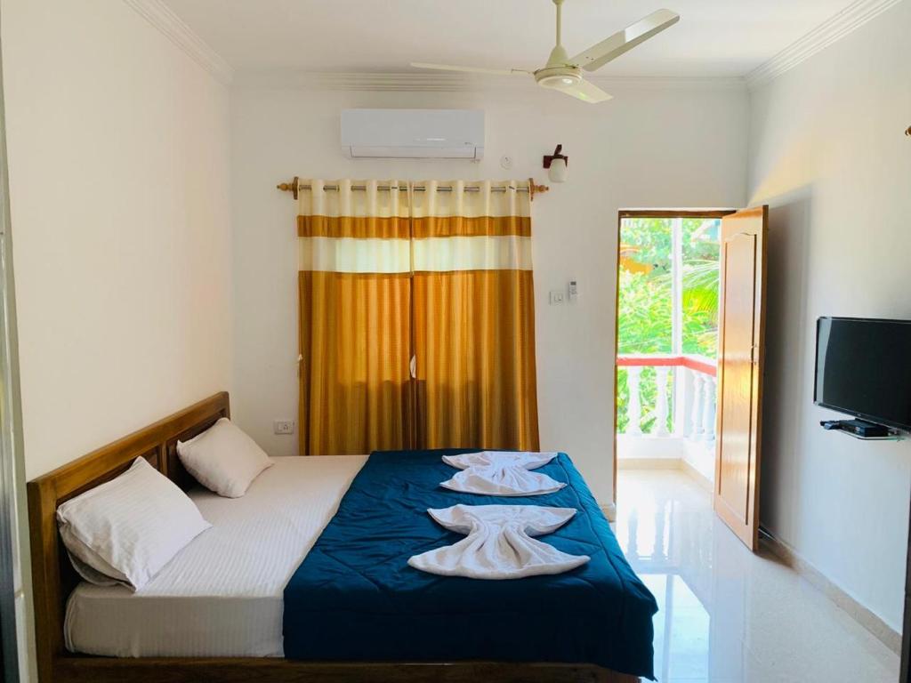 a bedroom with a bed with two towels on it at Rosy Guest House in Calangute