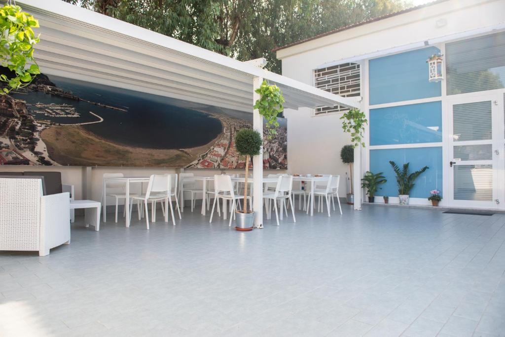 a patio with white chairs and a painting on the wall at Stabia Dream Rooms in Castellammare di Stabia