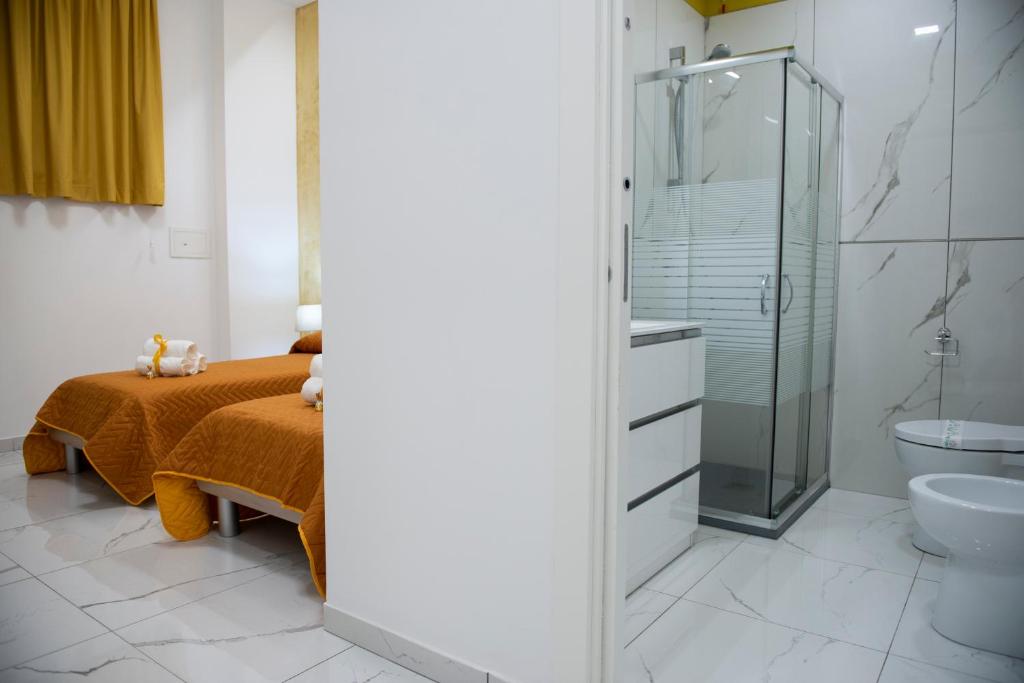 W łazience znajduje się łóżko i przeszklony prysznic. w obiekcie Stabia Dream Rooms w mieście Castellammare di Stabia