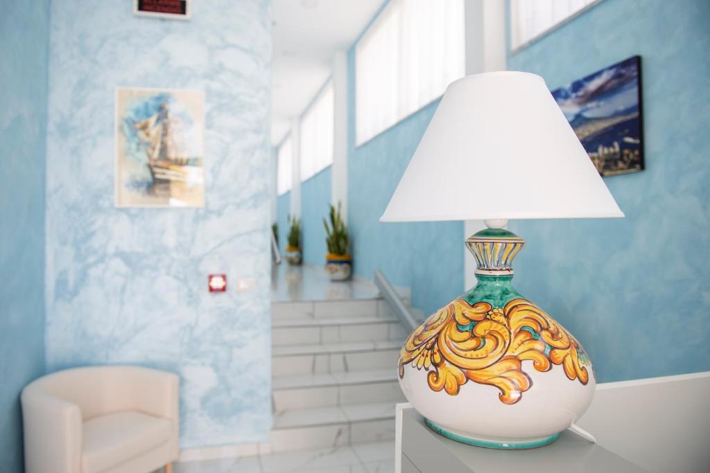 lampa siedząca na stole w pokoju w obiekcie Stabia Dream Rooms w mieście Castellammare di Stabia