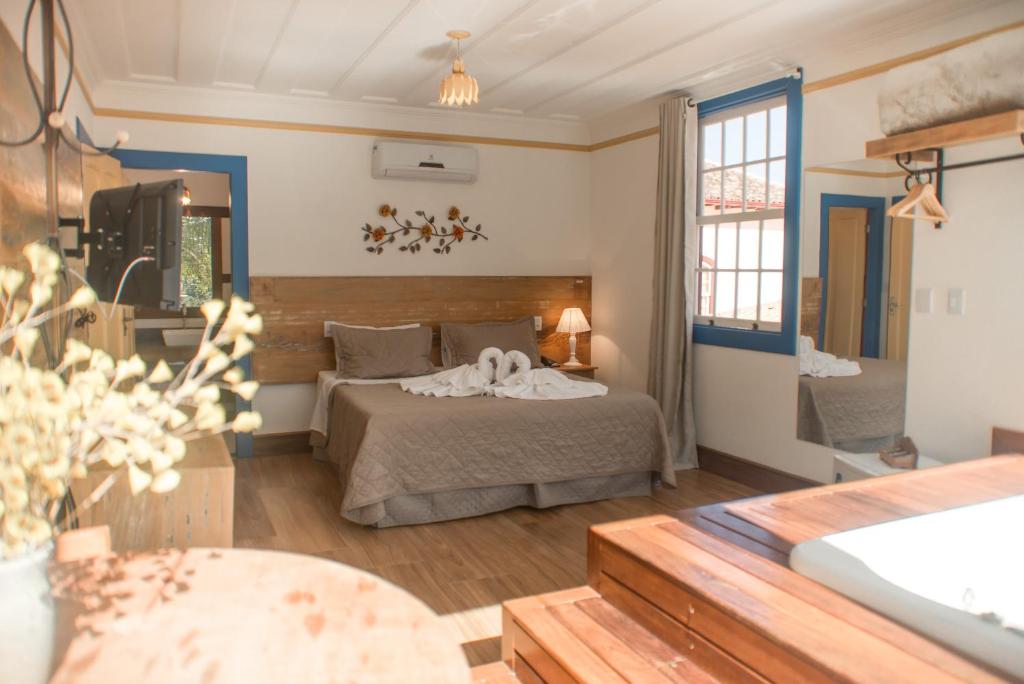 um quarto com uma cama e uma banheira num quarto em Hotel Recanto do Ouro - Antigo Recanto da Serra em Ouro Preto