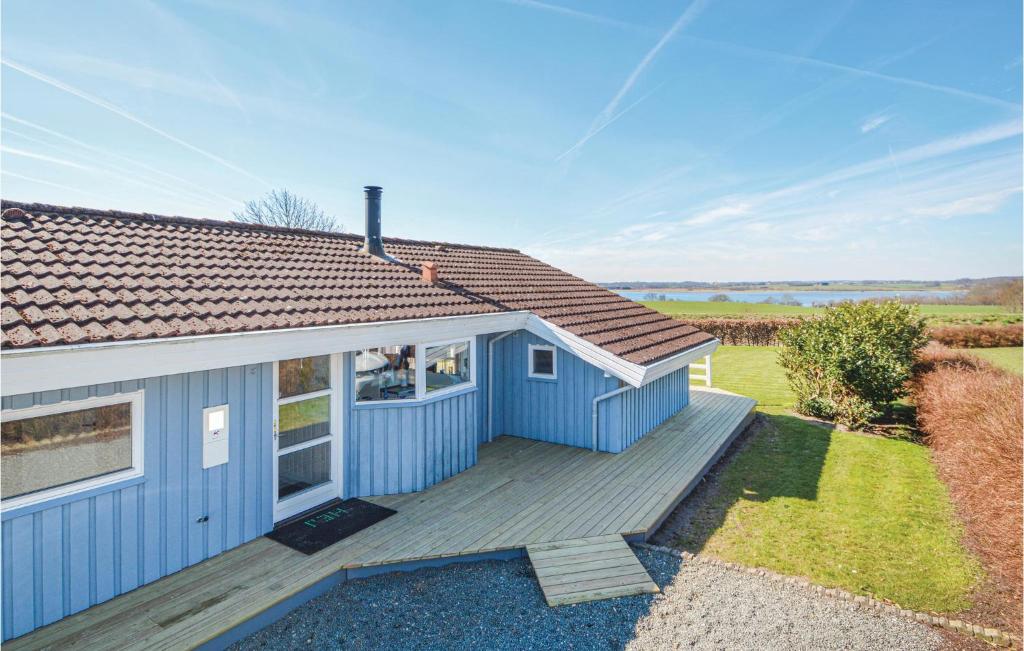 a blue house with a wooden deck next to a field at Holiday Home Søndervang Hejls in Hejls
