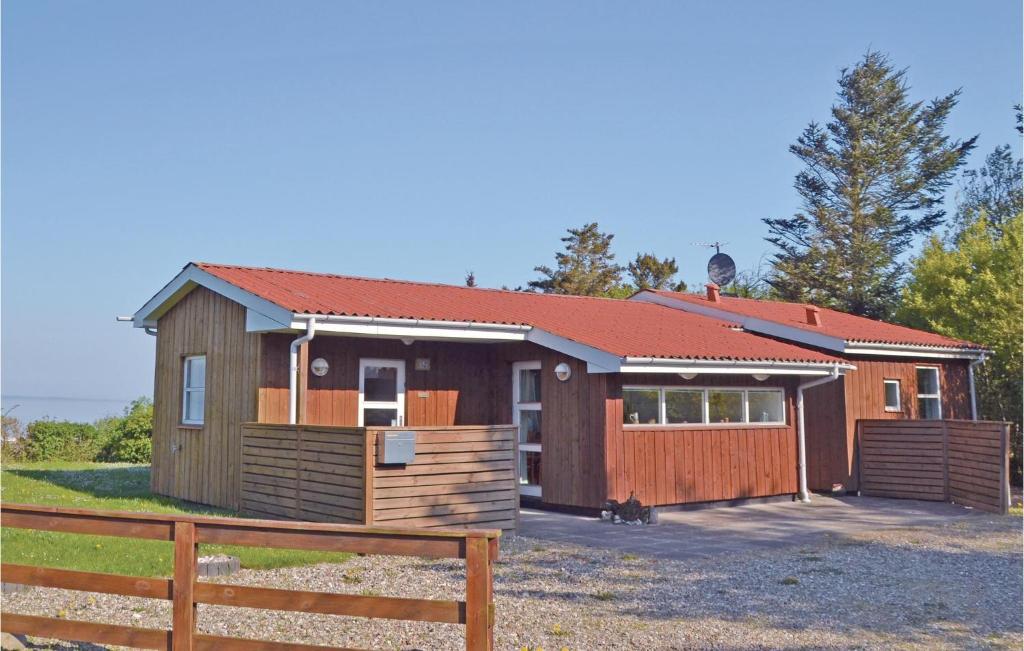 a large wooden house with a fence in front of it at Amazing Home In Lgstr With 2 Bedrooms in Løgstør