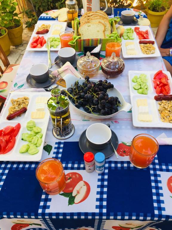 a long table with plates of food on it at Jemin Apartment in Berat