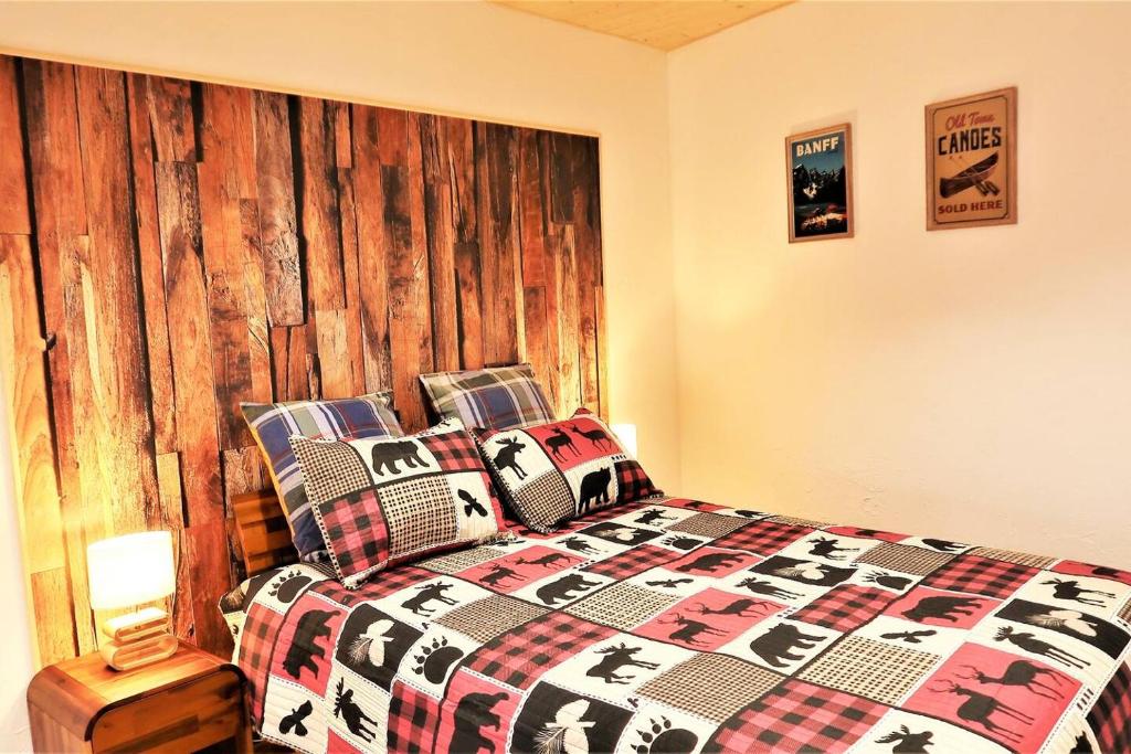 een slaapkamer met een bed met een houten hoofdeinde bij Appart'Confort - Le Lodge in Saint-Brieuc