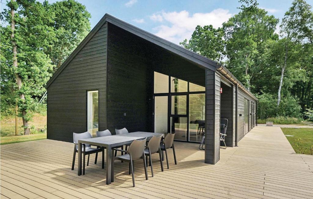 una casa negra con una mesa y sillas en una terraza en Four-Bedroom Holiday Home In Glesborg, en Glesborg