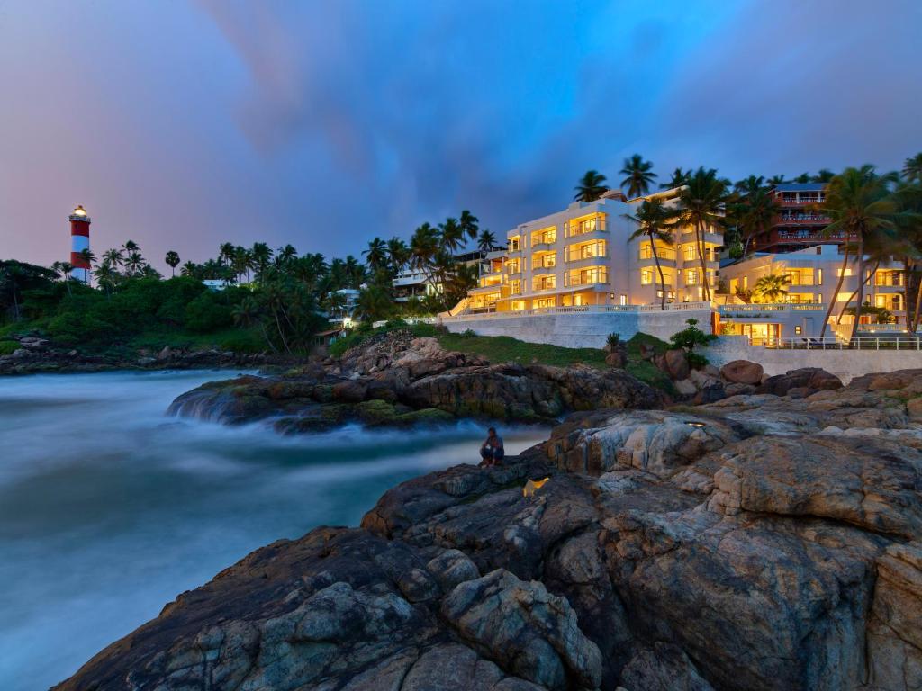 un hotel en la orilla del océano por la noche en Rockholm at the Light House Beach en Kovalam