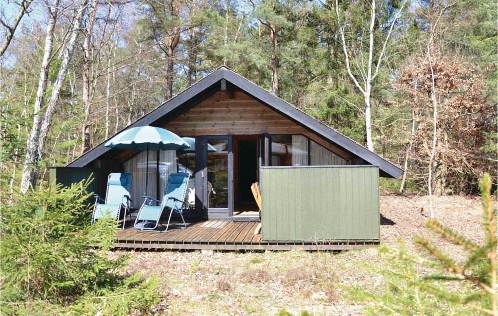 a cabin with a deck in the woods at Two-Bedroom Holiday Home In Frederiksvark in Frederiksværk
