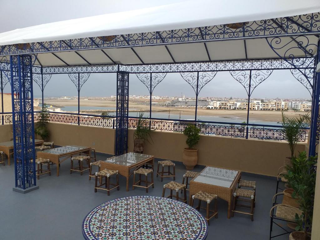 een balkon met tafels en stoelen en uitzicht op een luchthaven bij dar wassim el ghali in Rabat