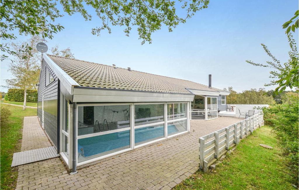 エーベルトフトにあるNice Home In Ebeltoft With 6 Bedrooms, Wifi And Indoor Swimming Poolの裏庭のスイミングプール付きハウス