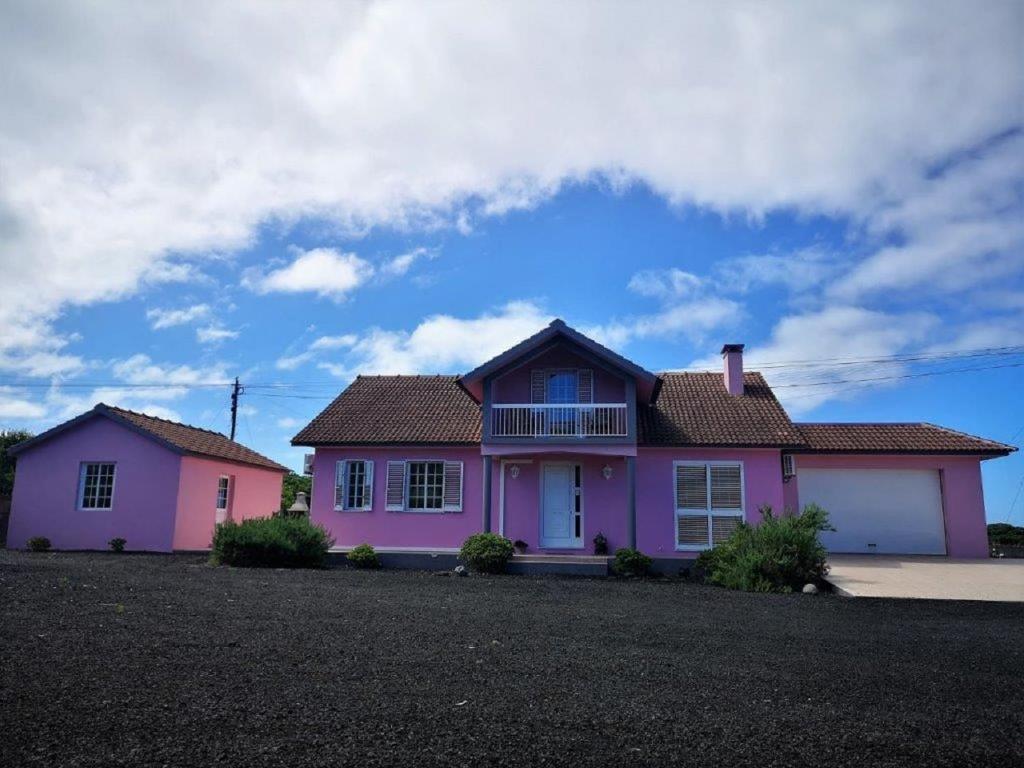 a pink house with a black roof at Villa da Silva in Madalena