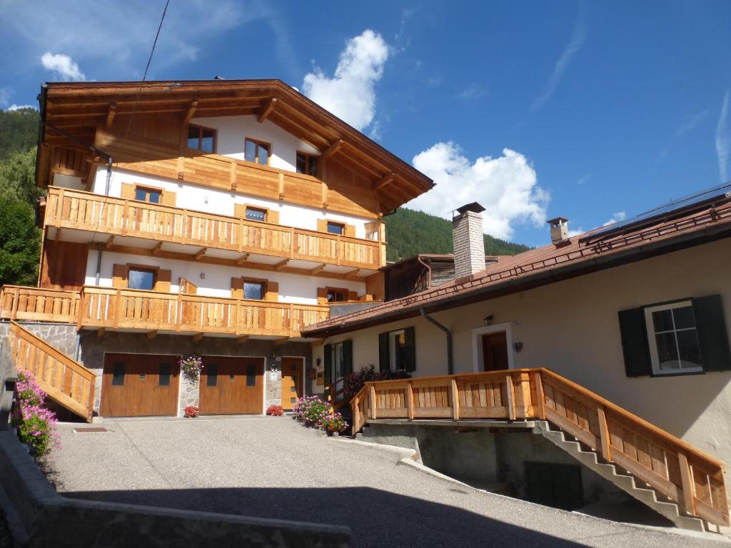 a large house with a wooden balcony on the side at Casa Dorich in Pozza di Fassa