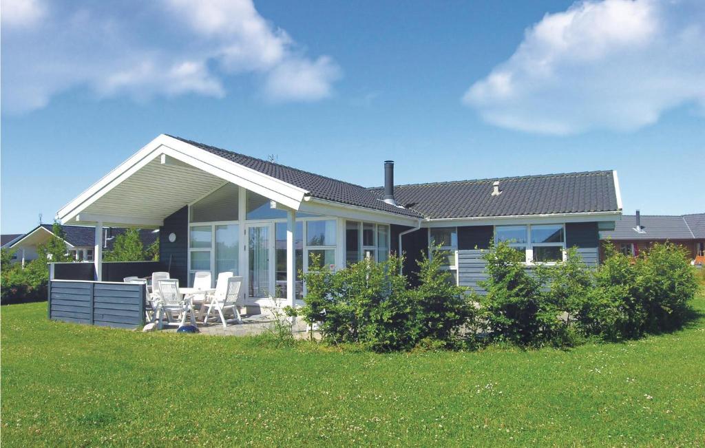 a house with a porch and chairs in a yard at Holiday Home Strandparken in Otterup