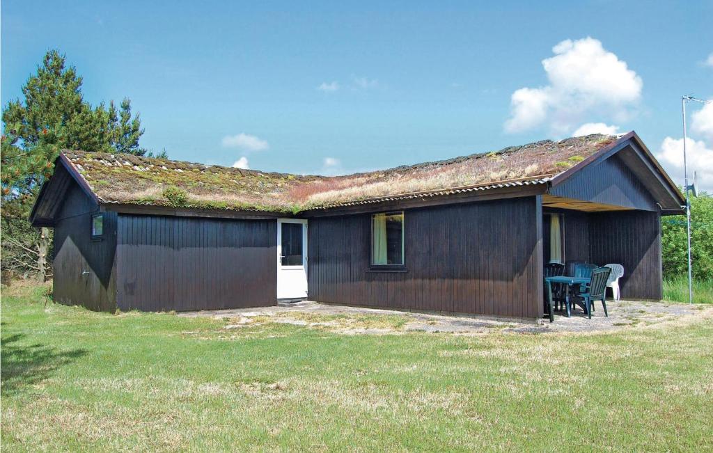 una pequeña casa con un techo cubierto de musgo y un patio en 3 Bedroom Stunning Home In Rm, en Bolilmark