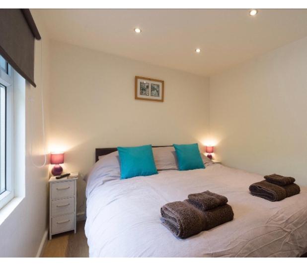 a bedroom with a large white bed with blue pillows at Alexandra Annexe in Bath