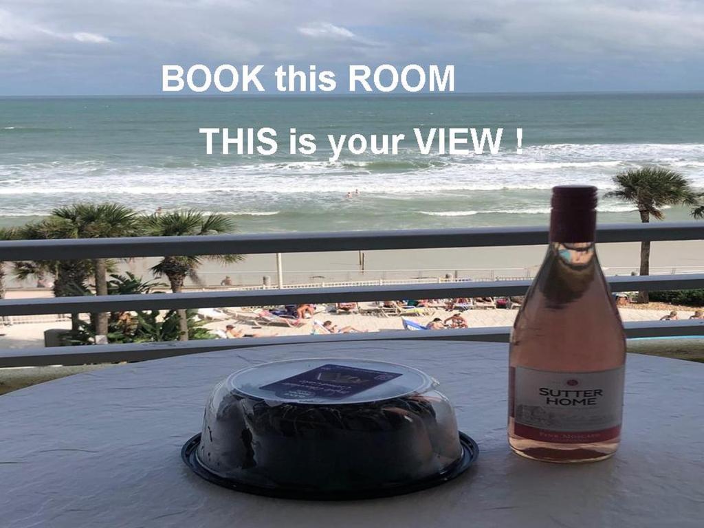 una bottiglia di vino seduta su un tavolo con una torta di Ocean Walk Resort 505 a Daytona Beach