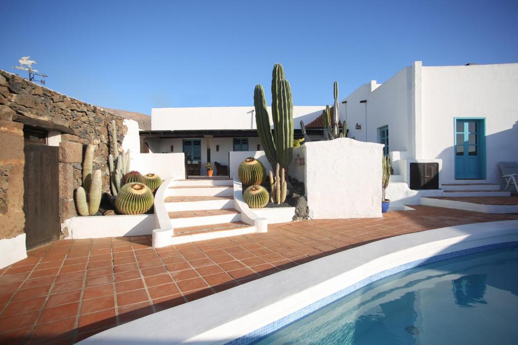 a swimming pool with cacti and stairs next to a house at Casa Camella in Mácher