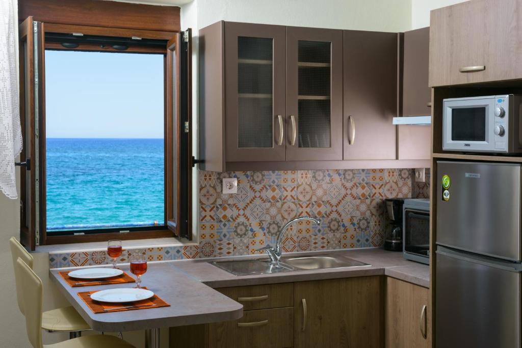 cocina con fregadero y ventana con vistas al océano en BEACH HOUSE en Milatos