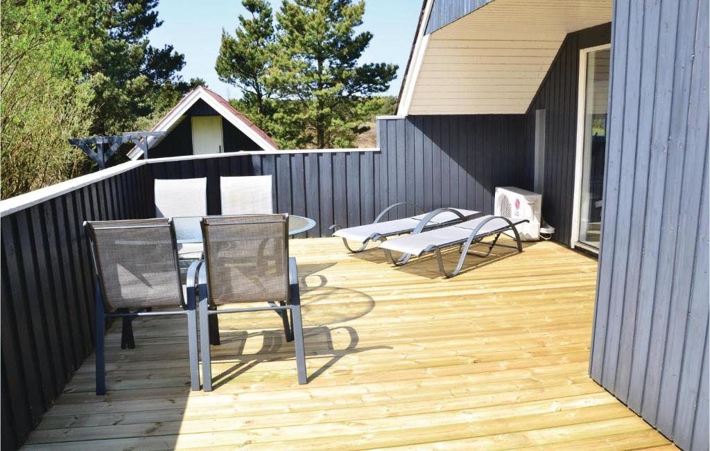 een houten terras met 2 stoelen en een tafel bij Amazing Home In Fan With Wifi in Sønderho