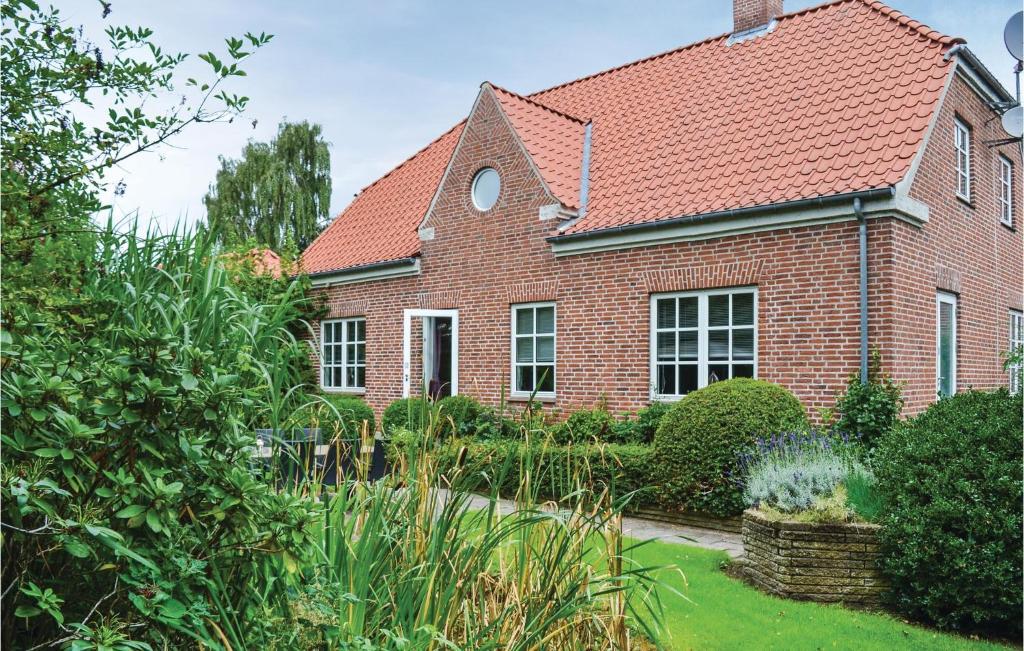 a brick house with a red roof at Amazing Home In Eg With 4 Bedrooms And Wifi in Skæring
