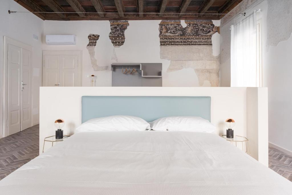 una camera bianca con un grande letto bianco di Residenza Giulio Romano a Mantova
