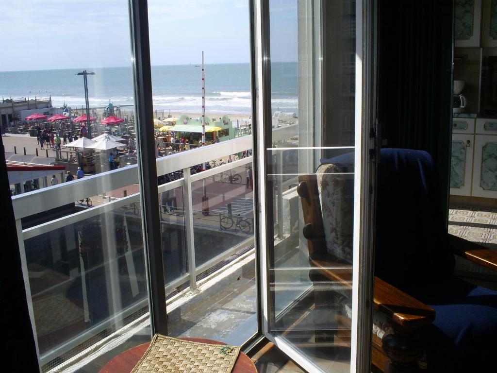 a room with a view of the ocean from a balcony at Charlierhelling app 22 in Blankenberge