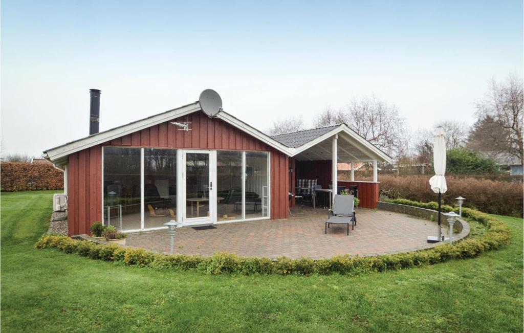 un fienile rosso con un patio nel cortile di Three-Bedroom Holiday Home In Hejls a Hejls