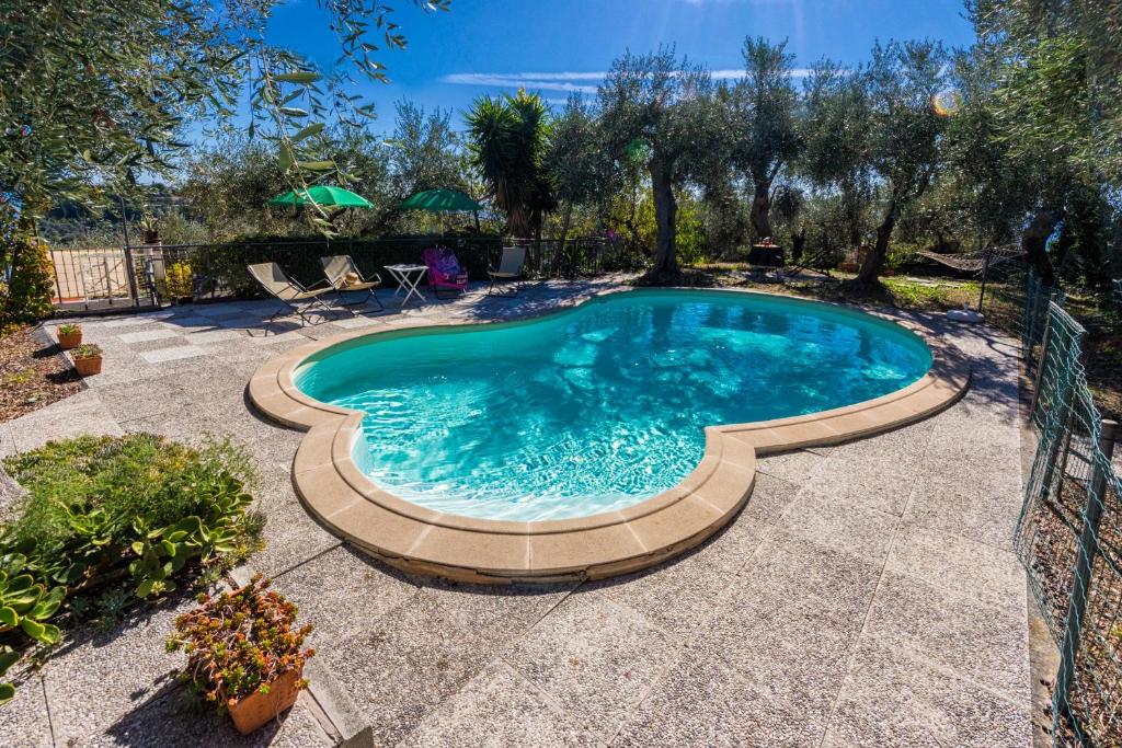 een zwembad in een tuin met een patio bij Le Navi In Cielo in Imperia